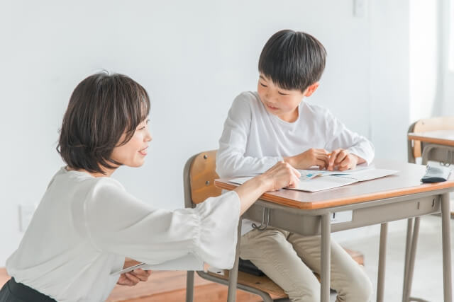 教室で学ぶ子供と女性教師