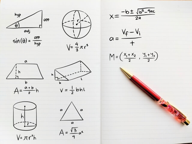 幾何学の図形を描いたノートと赤いペン